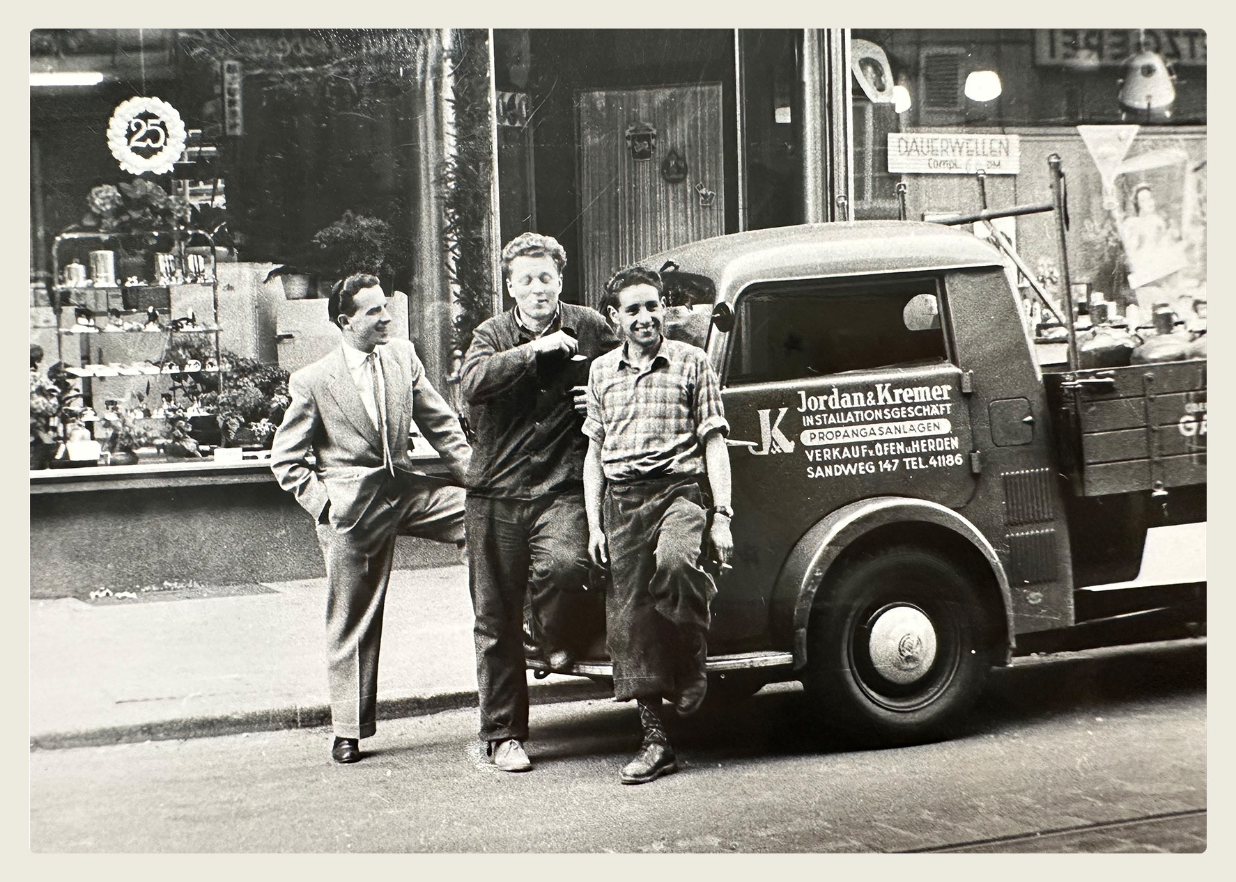 Drei Mitarbeiter der Firma Jodan & Kremer mit einem Gasflaschen-Transporter, historische Aufnahme aus dem Archiv