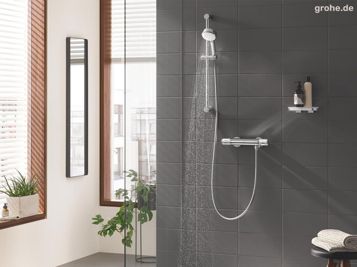 Badezimmerdusche mit Grohe Armatur und grauen Wandfliesen
